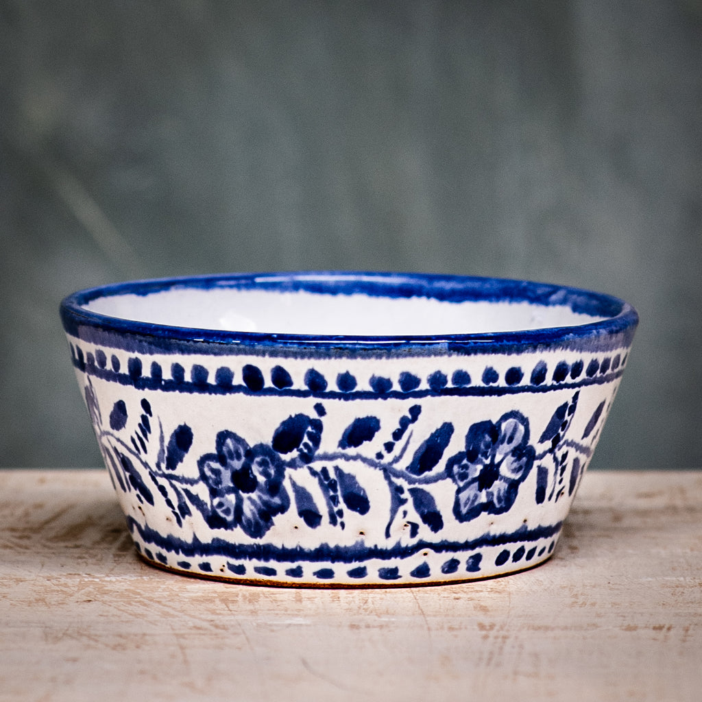 A square ceramic bowl with a blue floral pattern on a white background.