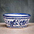 A square ceramic bowl with a blue floral pattern on a white background.