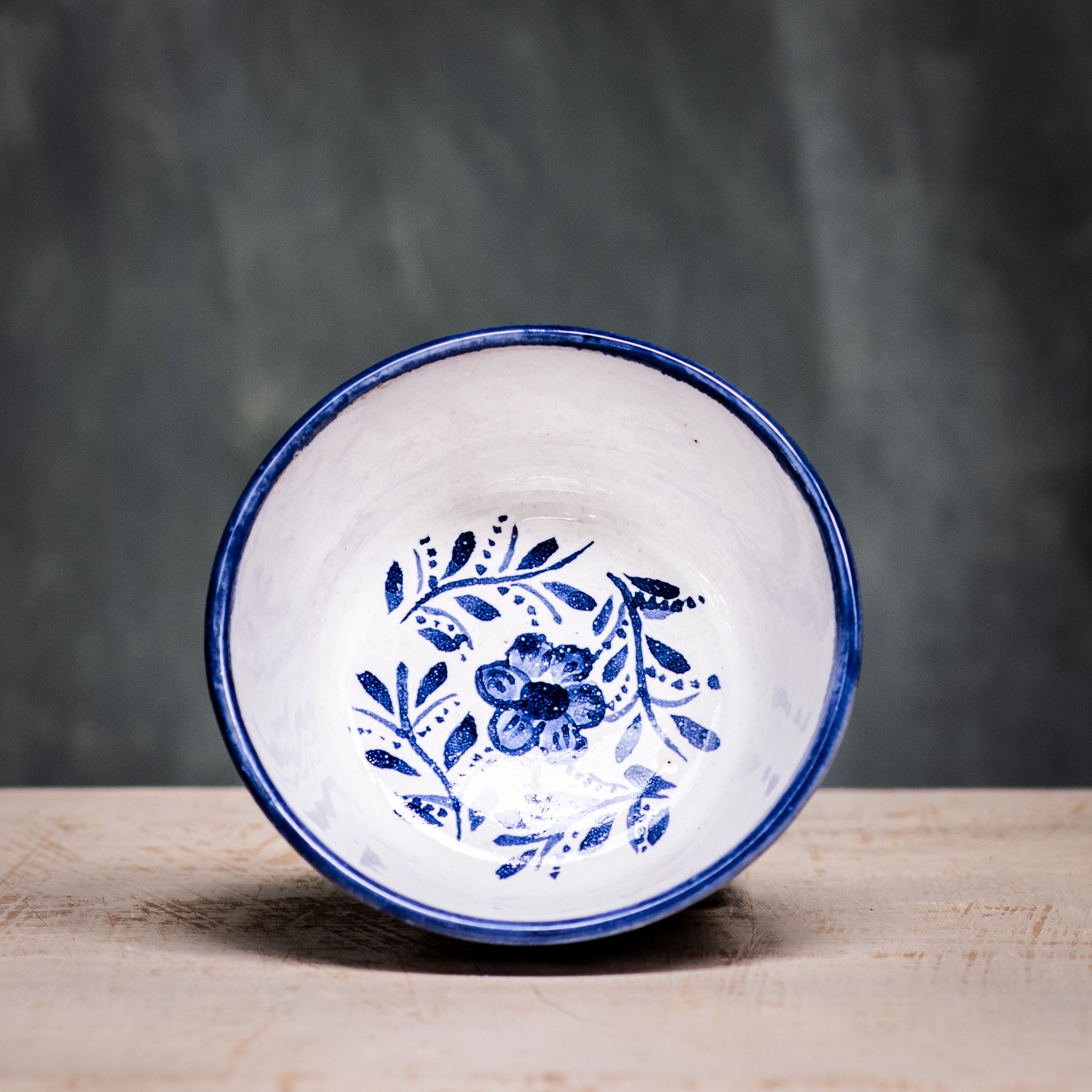 A square ceramic bowl with a blue floral pattern on a white background.