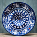 A medium-sized, round ceramic chip and dip bowl with a blue floral pattern on a white background.