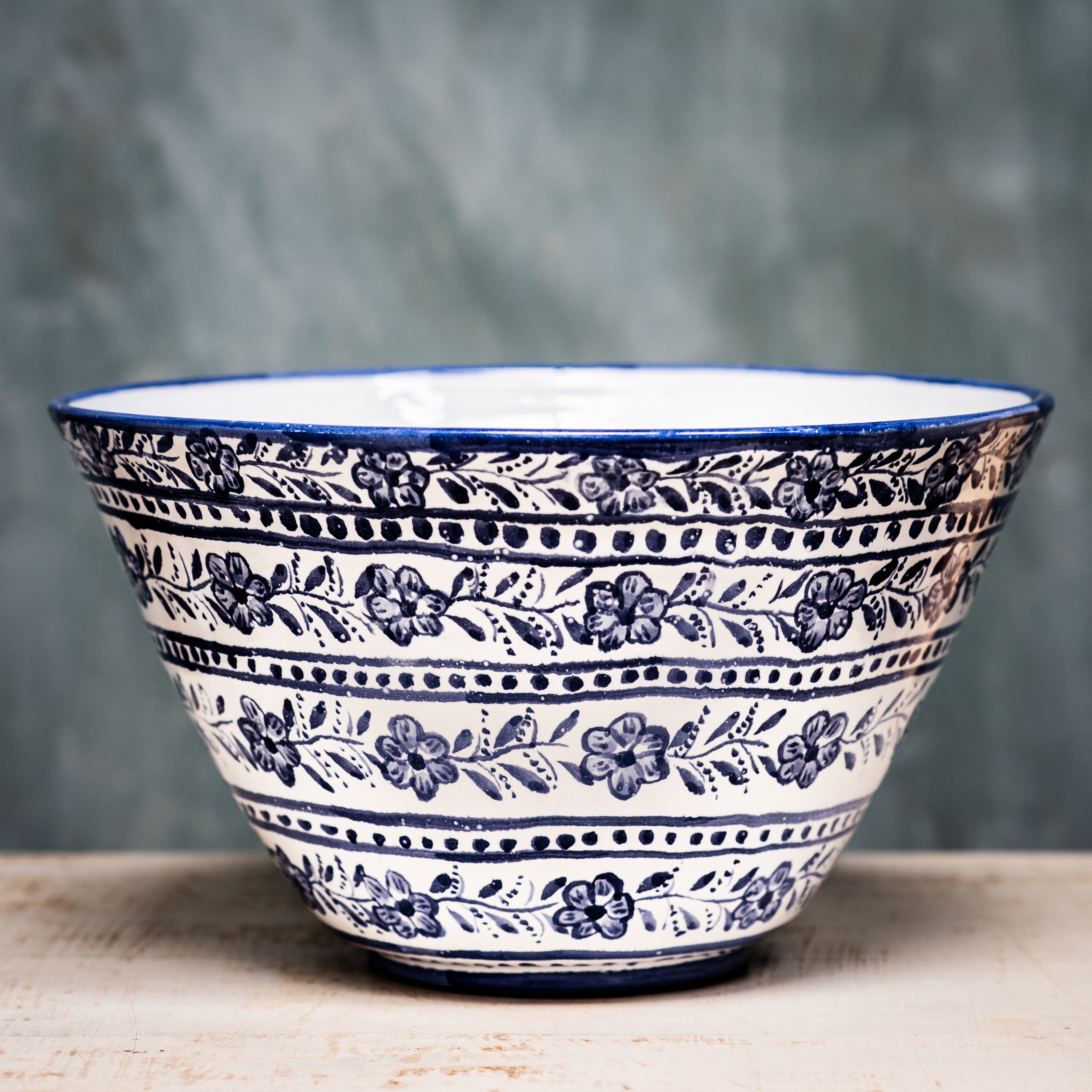 A round ceramic salad bowl with a deep blue pattern on the lower half and a plain white upper half.