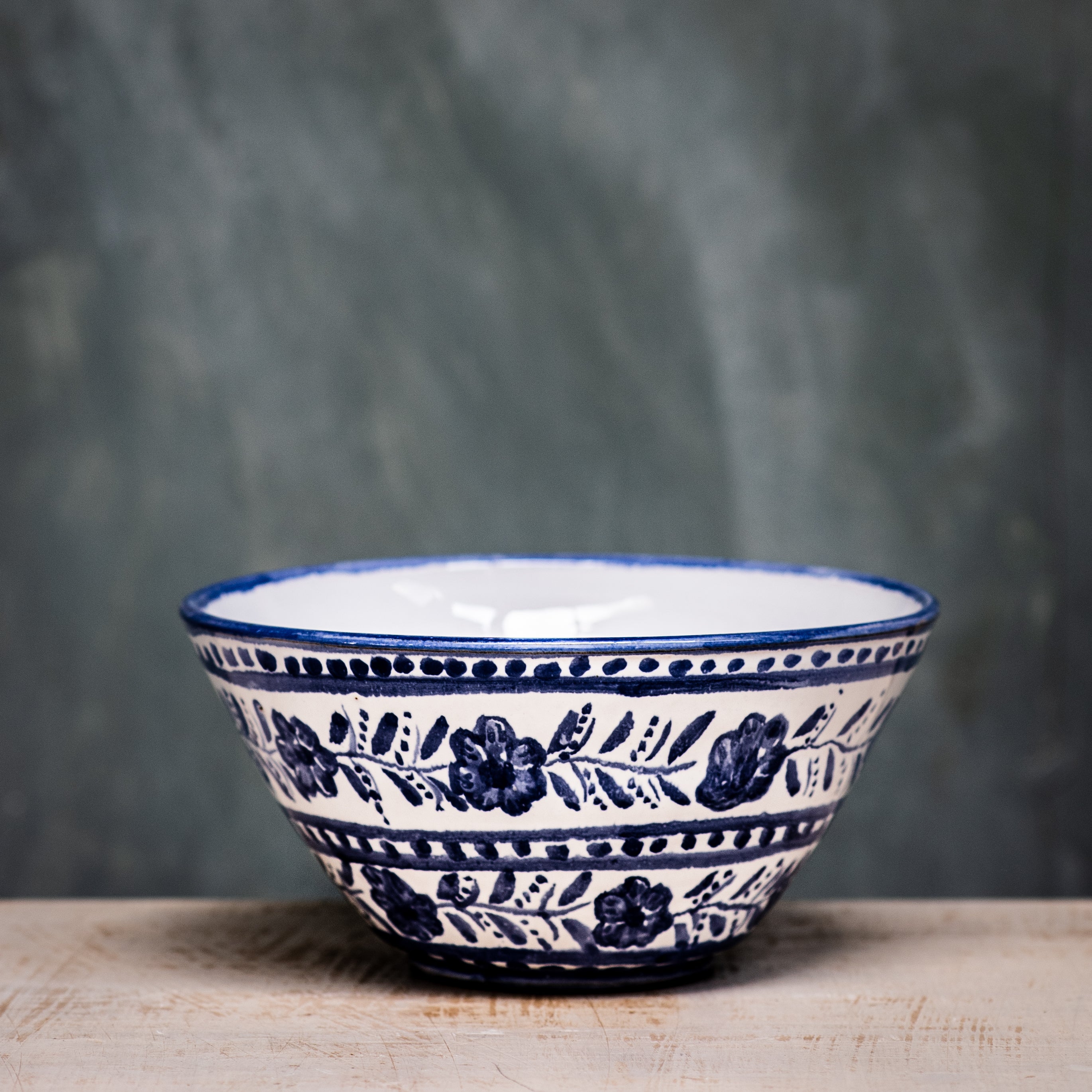 A ceramic pudding bowl with a floral pattern in blue and white colors on a white background.