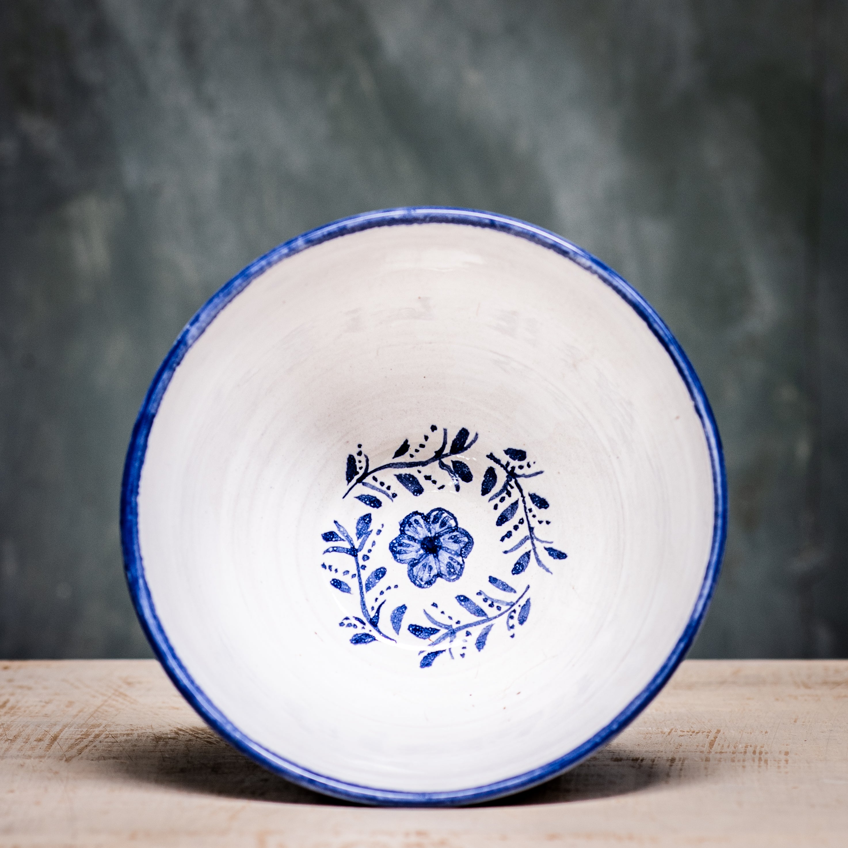 A ceramic pudding bowl with a floral pattern in blue and white colors on a white background.